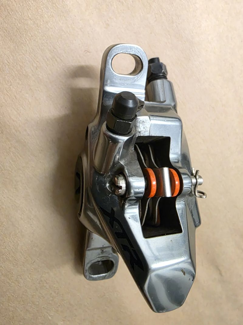 Třmen Shimano XTR 9100 a destičky TrickStuff