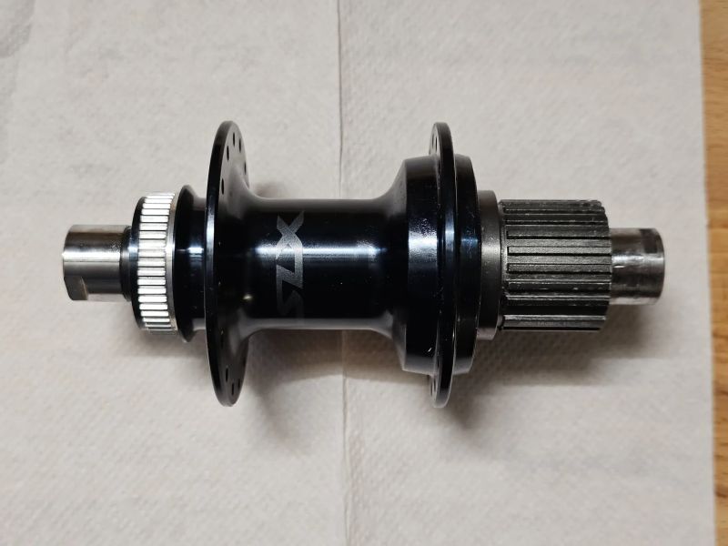 Zadní náboj Shimano SLX FH-M7110, 32 děr, 12x142 mm pro microspline; nefunkční ořech!
