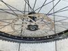 Přední kolo s nábojem Shimano SLX a ráfkem KLS plášťem Maxxis a kotoučem Shimano 203 mm