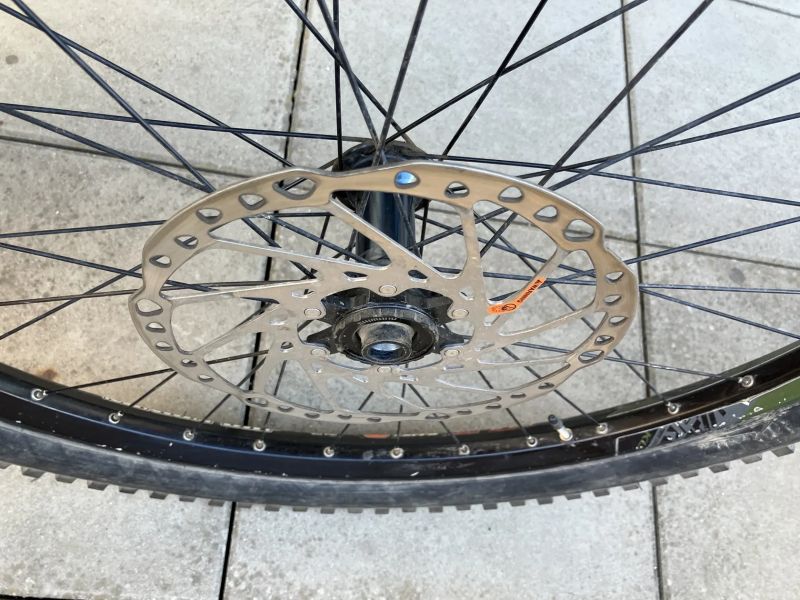 Přední kolo s nábojem Shimano SLX a ráfkem KLS plášťem Maxxis a kotoučem Shimano 203 mm