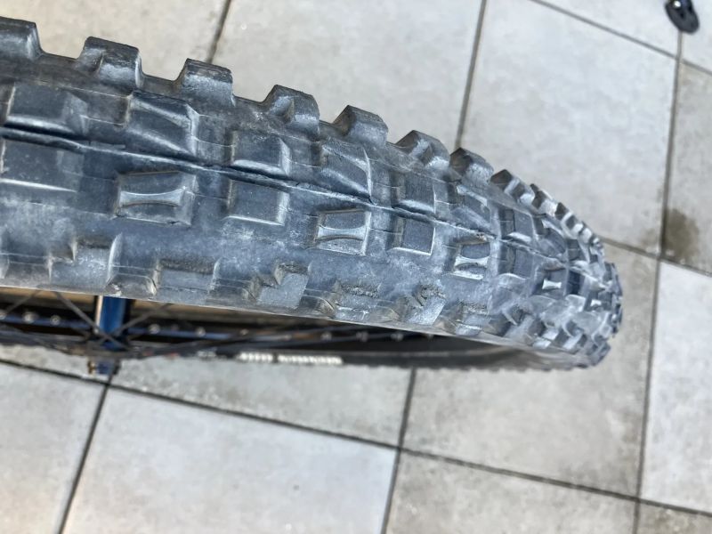 Přední kolo s nábojem Shimano SLX a ráfkem KLS plášťem Maxxis a kotoučem Shimano 203 mm