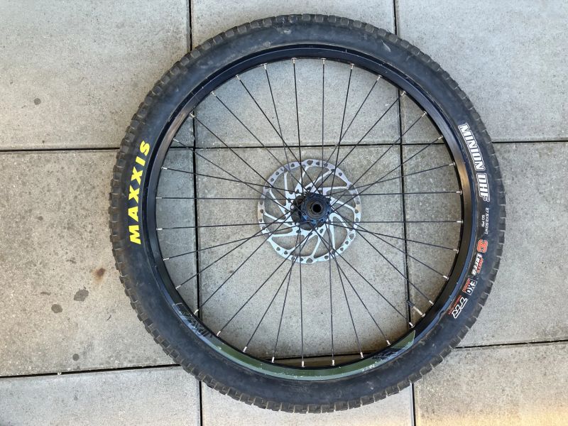 Přední kolo s nábojem Shimano SLX a ráfkem KLS plášťem Maxxis a kotoučem Shimano 203 mm